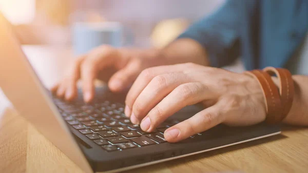 Close-up Shot of a Man Typing on a Laptop at Home Office. Shot Made with Warm Sun Light. — Stock Photo, Image