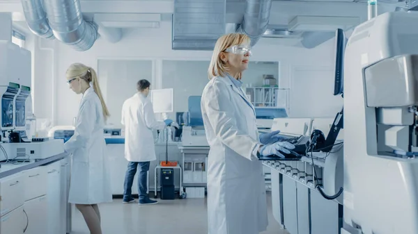 Equipe de Pesquisadores Trabalhando em Computador, com Equipamentos Médicos, Analisando Amostras de Sangue e Materiais Genéticos com Máquinas Especiais no Laboratório Moderno. — Fotografia de Stock