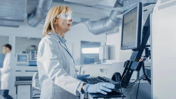 Le scienziate programmano attrezzature mediche con personal computer. Team di professionisti che lavorano nel laboratorio moderno di ricerca farmaceutica. — Foto Stock