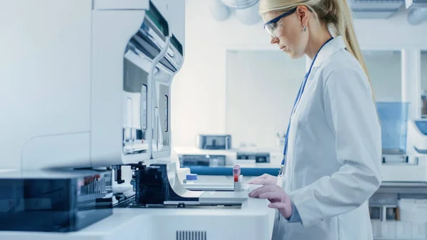 2015 년 12 월 1 일에 확인 함 . Female Research Scientist Pying Test Tubes with Blood Samples into Analyzer Medical Machine. 과학자들이 제약 연구소에서 현대 의학 장비를 개발하다. — 스톡 사진