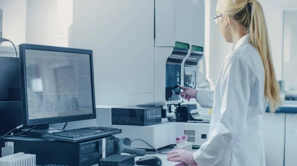Científica investigadora que trabaja con la máquina de análisis médico para probar tubos con muestra de sangre. Científico trabaja en laboratorio de investigación genética farmacéutica innovadora. —  Fotos de Stock