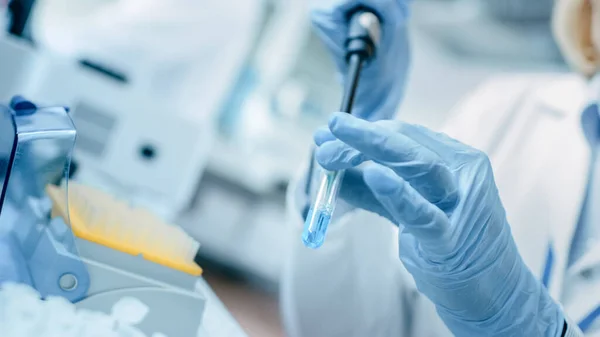 Close-up of the Hand in Glove Menggunakan Micro Pipette saat bekerja dengan Test Tubes. Orang-orang di Laboratorium Farmasi Inovatif dengan Peralatan Medis Modern untuk Penelitian Genetika. — Stok Foto