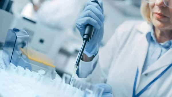 Közelkép a kéz a kesztyűben Micro Pipette használata közben dolgozik Test Tubes. Emberek az innovatív gyógyszerészeti laboratóriumban modern orvosi berendezésekkel a genetikai kutatáshoz. — Stock Fotó