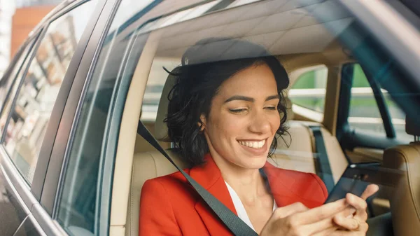 Schöne Frau, die im Auto unterwegs ist, auf dem Beifahrersitz sitzt, Smartphone benutzt, Nachrichten tippt, im Internet surft. Kamerafahrt von außerhalb des Fahrzeugs. — Stockfoto