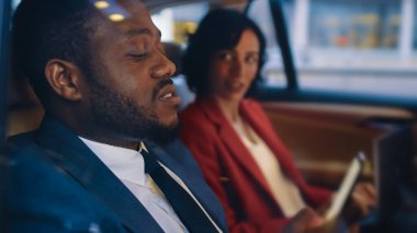 Genç Kadın ve Adam Akşamları Bir Arabanın Arka Koltuğunda Biniyor. Adam Smartphone kullanıyor. Arabanın dışından çekilen kamera görüntüsü.