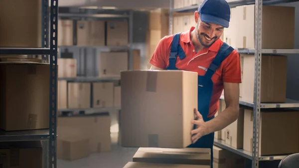 Warehouse Worker recolhe caixas de papelão e parcelas da prateleira e coloca-los no carrinho. — Fotografia de Stock