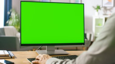 Green Mockup Ekran Kişisel Bilgisayarı üzerinde çalışan Profesyonel Serbest Çalışan Omuzcu Çekimi 'nin üzerinden. Mans Hands Daktilo Yazıyor, İnternet 'te geziniyor, Konfordaki Bilgisayarı kullanıyor