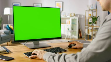Green Mockup Ekran Kişisel Bilgisayarı üzerinde çalışan Profesyonel Serbest Çalışan Omuzcu Çekimi 'nin üzerinden. Mans Hands Daktilo Yazıyor, İnternet 'te geziniyor, Konfordaki Bilgisayarı kullanıyor