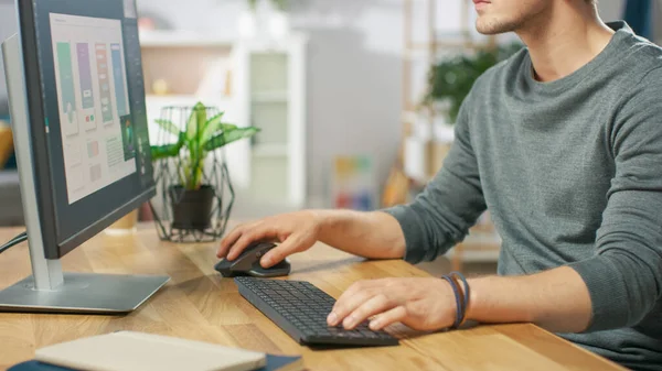 Detailní záběr člověka pomocí počítače a jeho rukou Psaní na klávesnici a pomocí myši. V pozadí útulný obývací pokoj. — Stock fotografie