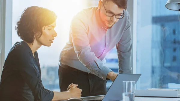 Hermosa empresaria que tiene lugar en su escritorio de trabajo en la oficina con vista a la ventana del paisaje urbano. Mujer exitosa que usa vestido de desgaste formal que trabaja en un ordenador portátil. Vista trasera descendente con toma de sol — Foto de Stock