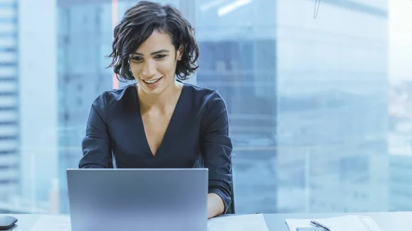 Portret van de succesvolle lachende zakenvrouw Werken op een laptop in haar kantoor met uitzicht op de stad venster. Mooie Independend Vrouwelijke CEO runs Company. — Stockfoto