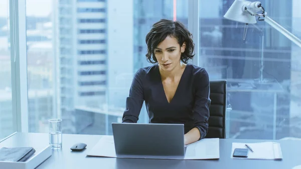 Portrait of the Successful Smiling Businesswoman Working on a Laptop in Her Office with Cityscape View Window. Beautiful Independend Female CEO Runs Company. — Stock Photo, Image