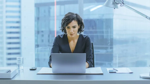 Portrait of the Successful Smiling Businesswoman Working on a Laptop in Her Office with Cityscape View Window. Beautiful Independend Female CEO Runs Company. — Stock Photo, Image