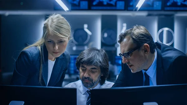 Operadores masculinos y femeninos que trabajan en computadoras en la sala de control del sistema. Analistas de agencias gubernamentales secretas investigando, investigando la seguridad cibernética. —  Fotos de Stock