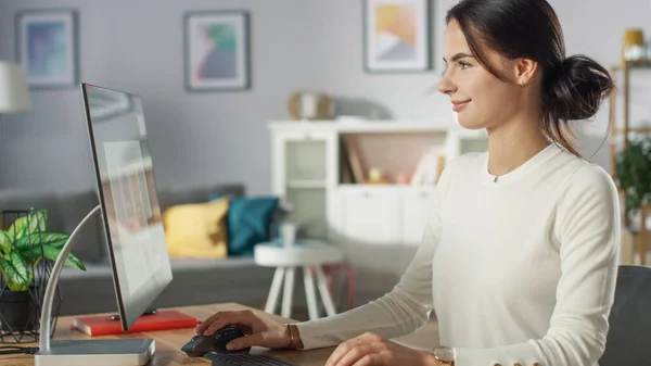 Porträtt av den vackra unga kvinnan som arbetar med mobil ansökan Design på sin dator hemma. — Stockfoto