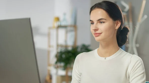 Közelkép portré a gyönyörű fiatal nőről, aki személyi számítógépen dolgozik a kényelmes nappalijából. Elbűvölően mosolyog. Lassú mozgásban.. — Stock Fotó