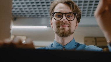 İçerideki Karton Paket Kutusundan Görünüm: Depo İşçisi Ürünleri Teslimat İçin Dikkatli Paketliyor, Kabarcık Paketi ile Güvenliğe Aldı.