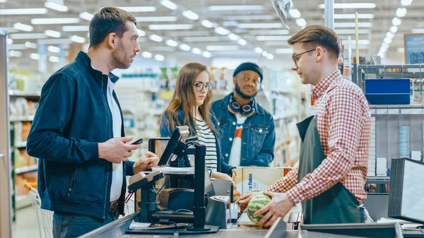At the Supermarket: Checkout Counter Customer Pays with Smartphone for His Items. Big Shopping Mall with Friendly Cashier, Small Lines and Modern Wireless Paying Terminal System. — Stock Photo, Image