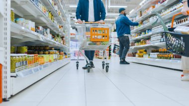 Süpermarkette Düşük Açılı Görüntü: Konserve Ürünler Bölümü, Müşteriler Rafları Tarayarak ve Ürünleri Satın Alırken.