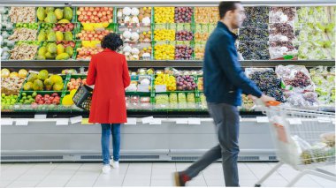 Süpermarkette: Kadın mağazanın Taze Ürün Bölümü 'nden Organik Meyveleri Seçiyor. Kavun topluyor ve onları alışveriş sepetine koyuyor. Arka Görünüm Görüntüsü.
