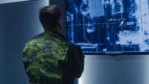 Military Man Army Officer Watches Satellite Surveillance Footage Car Tracking des Ziels an der Wand TV-Bildschirm. Geheime militärische Spionageoperation im Kontrollraum des Überwachungszentrums. — Stockfoto