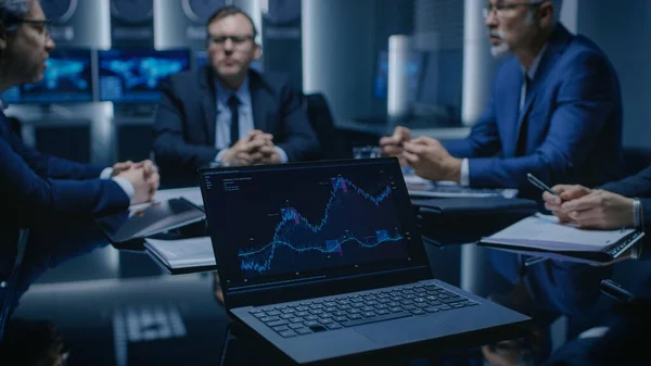 Auf dem Tisch Laptop mit Statistiken: Team aus Politikern, Unternehmensführern und Anwälten sitzt am Verhandlungstisch im Konferenzraum und versucht, zu einer Einigung zu kommen. — Stockfoto