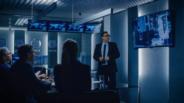 行动主任在墙上的电视屏幕上向一组政府特别探员展示监视录像。系统控制及监察室 — 图库照片