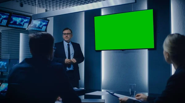 Chief Strategy Officer Visar rapport till en styrelse och affärspartner, med hjälp av Grön Mock-up Screen i övervakningsrummet. — Stockfoto