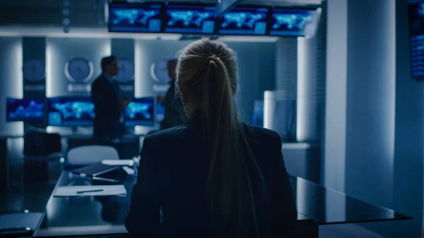 2015 년 12 월 9 일에 확인 함 . Female Special Agent Works on a Laptop in the Background Special Agent in Charge Talks To Military Man in Monitoring Room. In Background Busy System Control Center with Monitors show Data Flow. — 스톡 사진