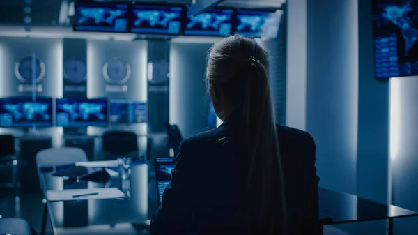 Female Special Agent Works on a Laptop in the Background Special Agent in Charge Talks To Military Man in Monitoring Room. In the Background Busy System Control Center with Monitors Showing Data Flow. — Stock Photo, Image