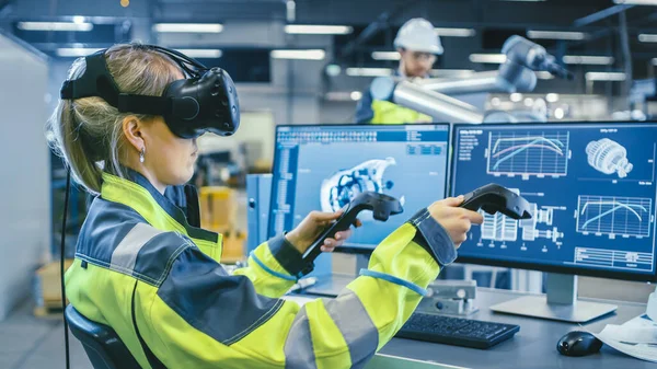 Továrna: Žena Průmyslový inženýr nosit virtuální realita sluchátka a holdingové regulátory, ona používá VR technologie pro průmyslový design, vývoj a prototypování v CAD software. — Stock fotografie