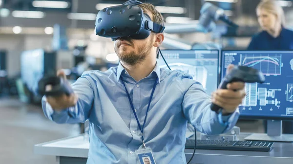 Retrato Tiro do Engenheiro Industrial Usando Headset Realidade Virtual e Usando Controladores, pronto para trabalhar. Na planta de fabricação de fundo e monitores. — Fotografia de Stock