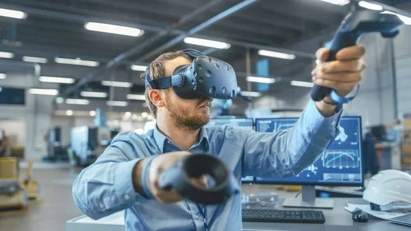 Porträtt Skott av industriingenjören bär Virtual Reality Headset och Använda styrenheter, redo att arbeta. I bakgrunden tillverkningsanläggning och monitorer. — Stockfoto