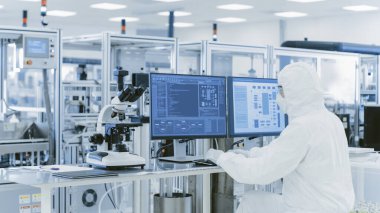 Kişisel Bilgisayarda Araştırma Yapan Koruyucu Giysiler Bilimadamının Omuz Görünümü Üzerindeki Laboratuvarda. Modern Manufactory Yarı iletkenler ve İlaç Ürünleri Üretimi.