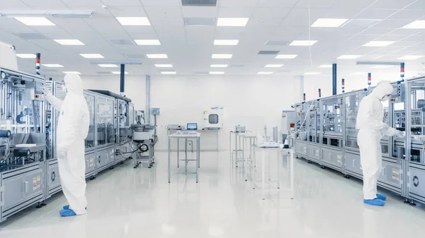 Вчені працюють в лабораторії. Завод з сучасними промисловими машинами. Процес виробництва продуктів: фармацевтика, напівпровідники, біотехнології . — стокове фото