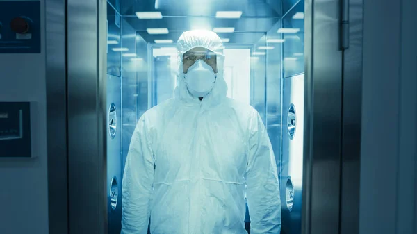 Vědec Virolog Factory Worker v kombinéze dezinfikuje sám sebe v dekontaminační sprchové komoře. Biohazardská pohotovostní reakce. — Stock fotografie