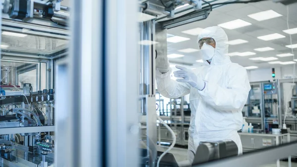 Nello stabilimento di produzione colpo di scienziato in indumenti protettivi sterili lavoro su un moderno macchinario di stampa 3D industriale. Creazione di prodotti farmaceutici, biotecnologici e semiconduttori — Foto Stock