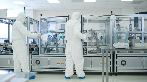 I produktionsanläggningen Team of Scientist bär sterila skyddande Coverall sätter upp program Modern industriell 3D-skrivare, hög precision tillverkning av halvledare under process. — Stockfoto