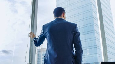 Ofisinde Takım Elbiseli İş Adamı 'nın Düşük Açı Çekimi ve Düşünerek Pencereden Bakışı. Büyük Şehir Manzaralı Modern İş Ofisi.