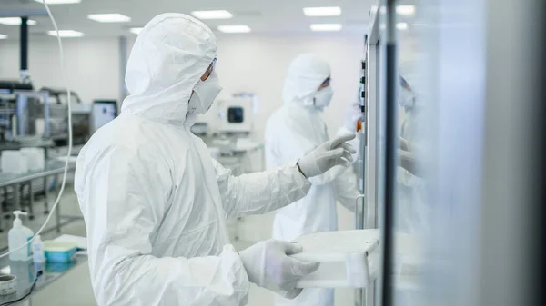Nel team dello stabilimento di produzione di scienziati che indossano una tuta protettiva sterile imposta programmi Stampante 3D industriale moderna, produzione ad alta precisione di semiconduttori in fase di processo. — Foto Stock