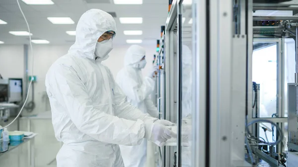 I produktionsanläggningen Team of Scientist bär sterila skyddande Coverall sätter upp program Modern industriell 3D-skrivare, hög precision tillverkning av halvledare under process. — Stockfoto