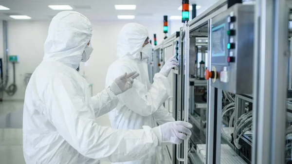 El equipo de científicos en ropa protectora estéril trabaja en una moderna maquinaria industrial de impresión 3D. Proceso de fabricación de productos farmacéuticos, biotecnológicos y semiconductores. — Foto de Stock