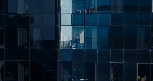 Vue aérienne de l'extérieur vers un immeuble de bureaux avec un homme d'affaires regardant par la fenêtre. Belle prise de vue des gratte-ciel du quartier financier. — Photo