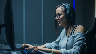 Güzel Profesyonel Oyuncu Kız, Kişisel Bilgisayarında Birinci Şahıs Nişancı Online Video Oyunu 'nda oynuyor. Sıradan sevimli inek kız kulaklık takıyor. Yeraltı Kumar Kulübü 'nde..