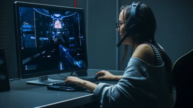 Beautiful Professional Gamer Girl Playing in First-Person Shooter Online Video Game on Her Personal Computer. Casual Cute Geek Girl Wearing Headset. In the Underground Gaming Club. clipart
