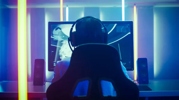 Voltar Ver tiro do jogador profissional jogando em primeira pessoa Shooter Jogo de vídeo on-line em seu computador pessoal. Quarto Lit by Neon Lights em estilo Retro Arcade. Internet cibernética online do e-esporte — Fotografia de Stock