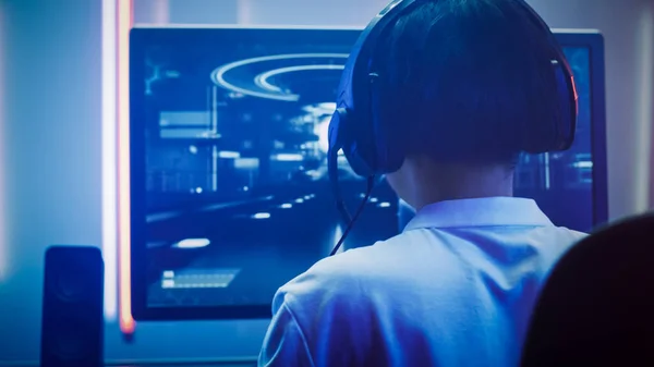 Professionell Gamer spelar i First-Person Shooter Online TV-spel på sin personliga dator. Han pratar med sitt team genom headset. Room Lit by Neon Lights in Retro Arcade Style. Cybersport — Stockfoto