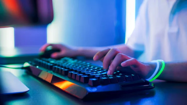 Primer plano de las manos del jugador jugando en el videojuego en un teclado y usando el ratón. Elegante Arcade Neon Brillante Rojo, Rosa, Violeta, Verde Colores. — Foto de Stock