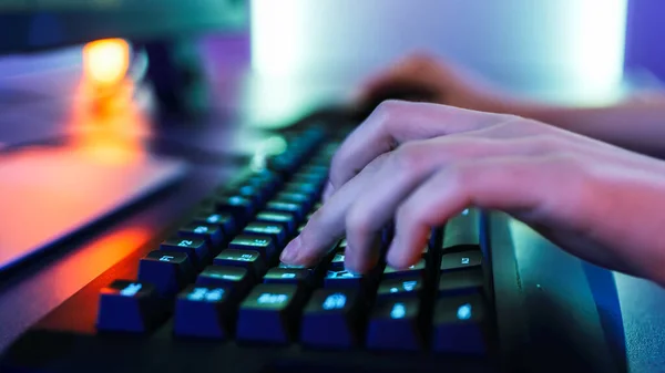 Close-up nas mãos do jogador jogando no jogo de vídeo em um teclado. Néon Arcade elegante vermelho brilhante, rosa, violeta, cores verdes. — Fotografia de Stock