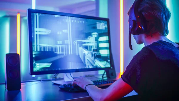 Shot of the Professional Gamer Playing in First-Person Shooter Juego de video en línea en su computadora personal. Habitación Lit by Neon Lights en estilo Arcade retro. Online Cyber e-Sport Campeonato de Internet. —  Fotos de Stock